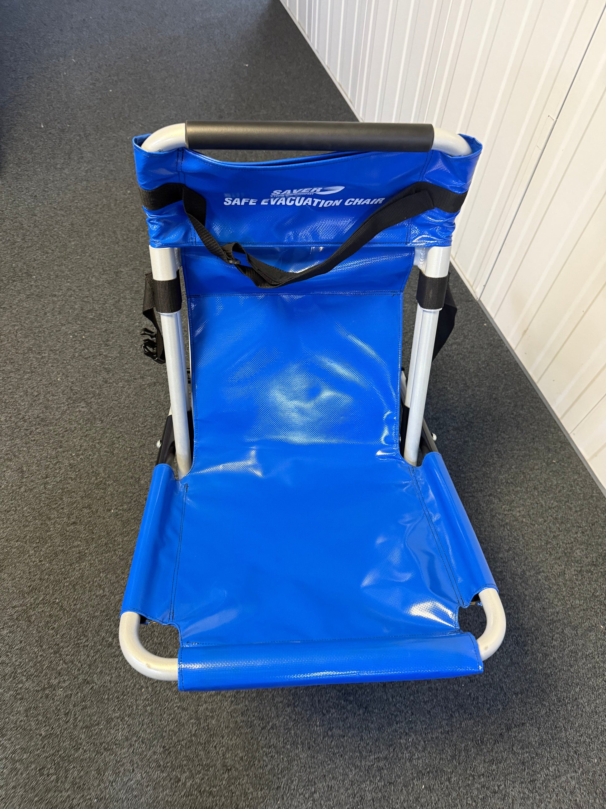 FERNO evacuation chair mounted on wall bracket with dust cover