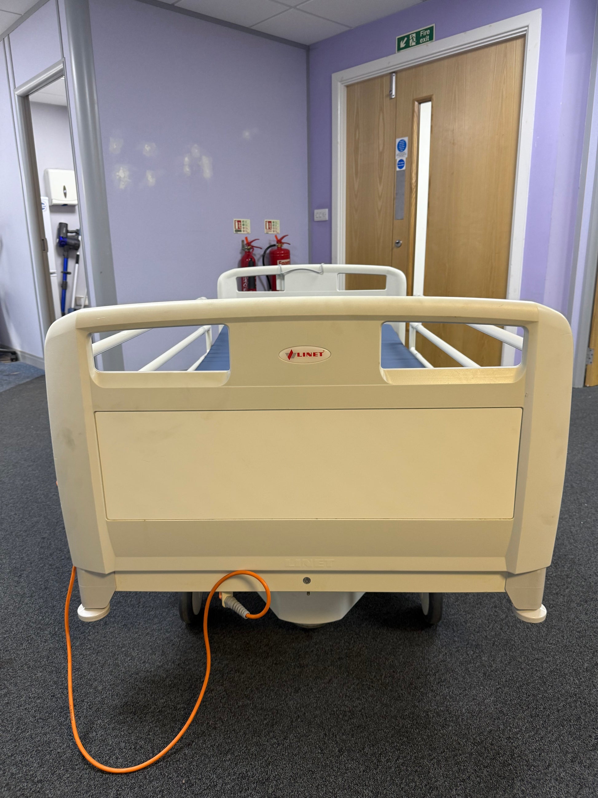 Linet hospital bed with side rail protectors and foot tray