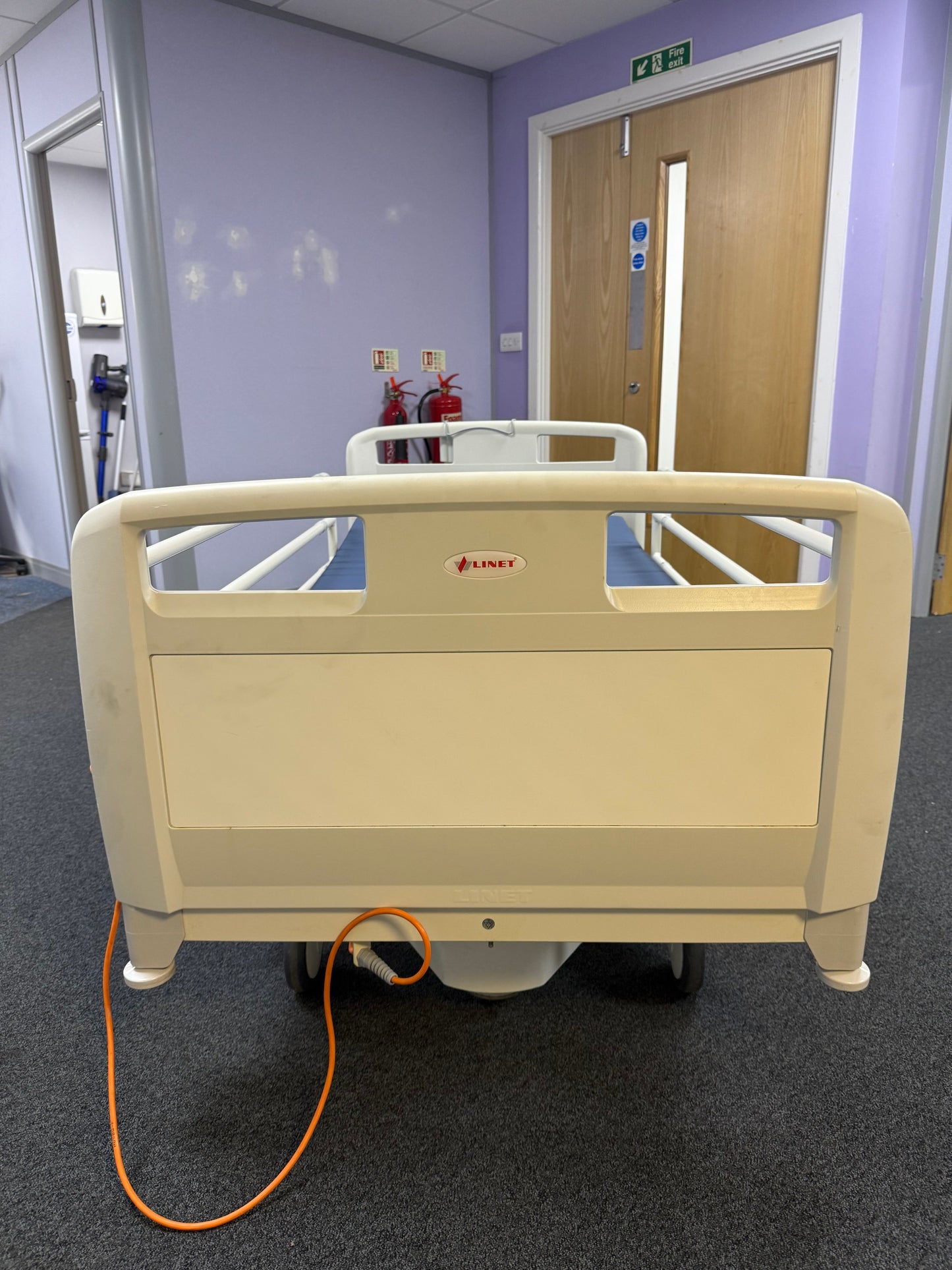Linet hospital bed with side rail protectors and foot tray